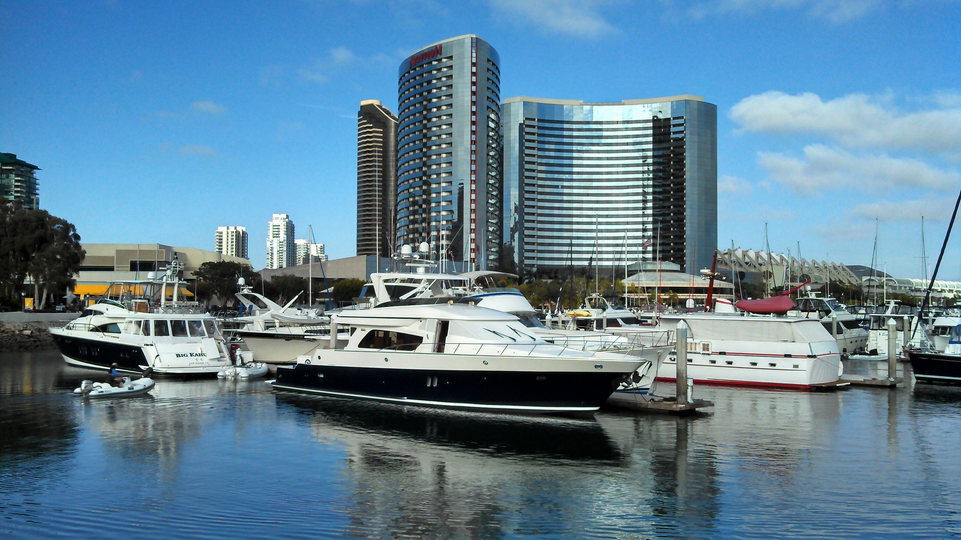 white and black boats on the boat ports with high rise building