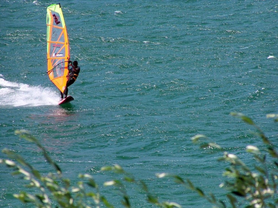 person on orange surfboard during daytime preview