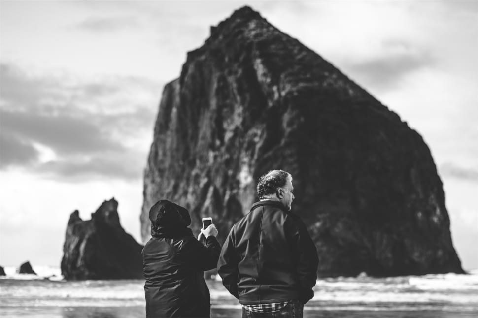 greyscale photo of man and woman in front of body of water preview