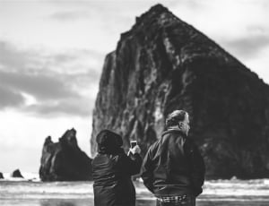 greyscale photo of man and woman in front of body of water thumbnail