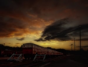 Red and White Train Taken during Sunset thumbnail