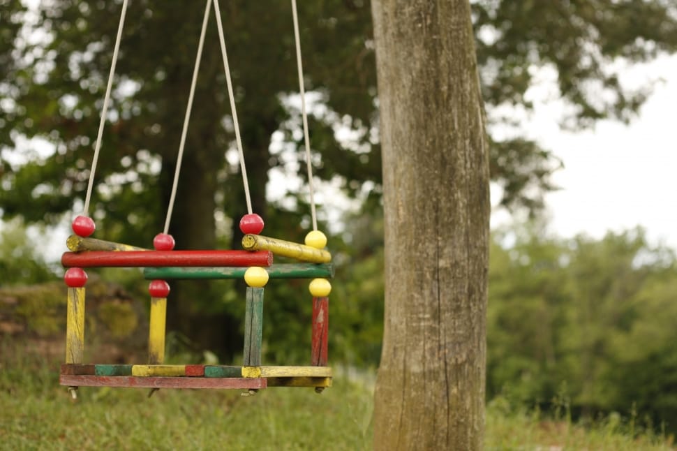 red, green, and yellow wooden swing chair preview