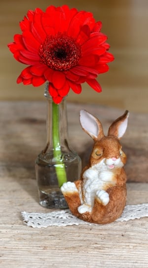 red gerbera daisy and brown bunny figurine thumbnail