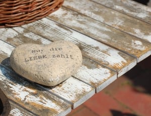 gray heart shape printed stone on top white and brown wooden table thumbnail