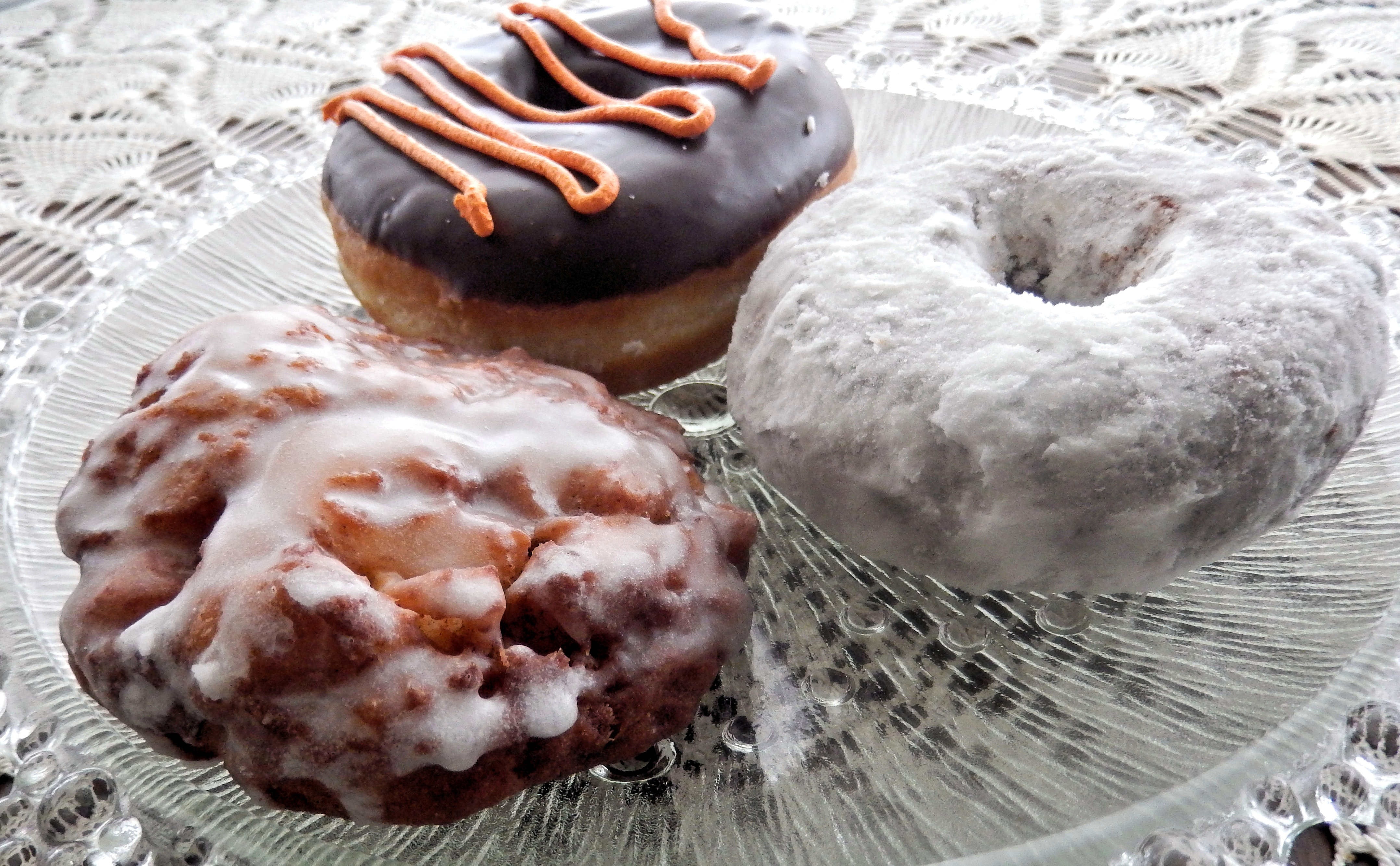 three donuts on clear round glass plate