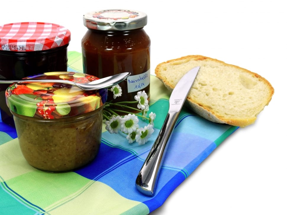 sliced bread beside bread knife near three glass food containers preview