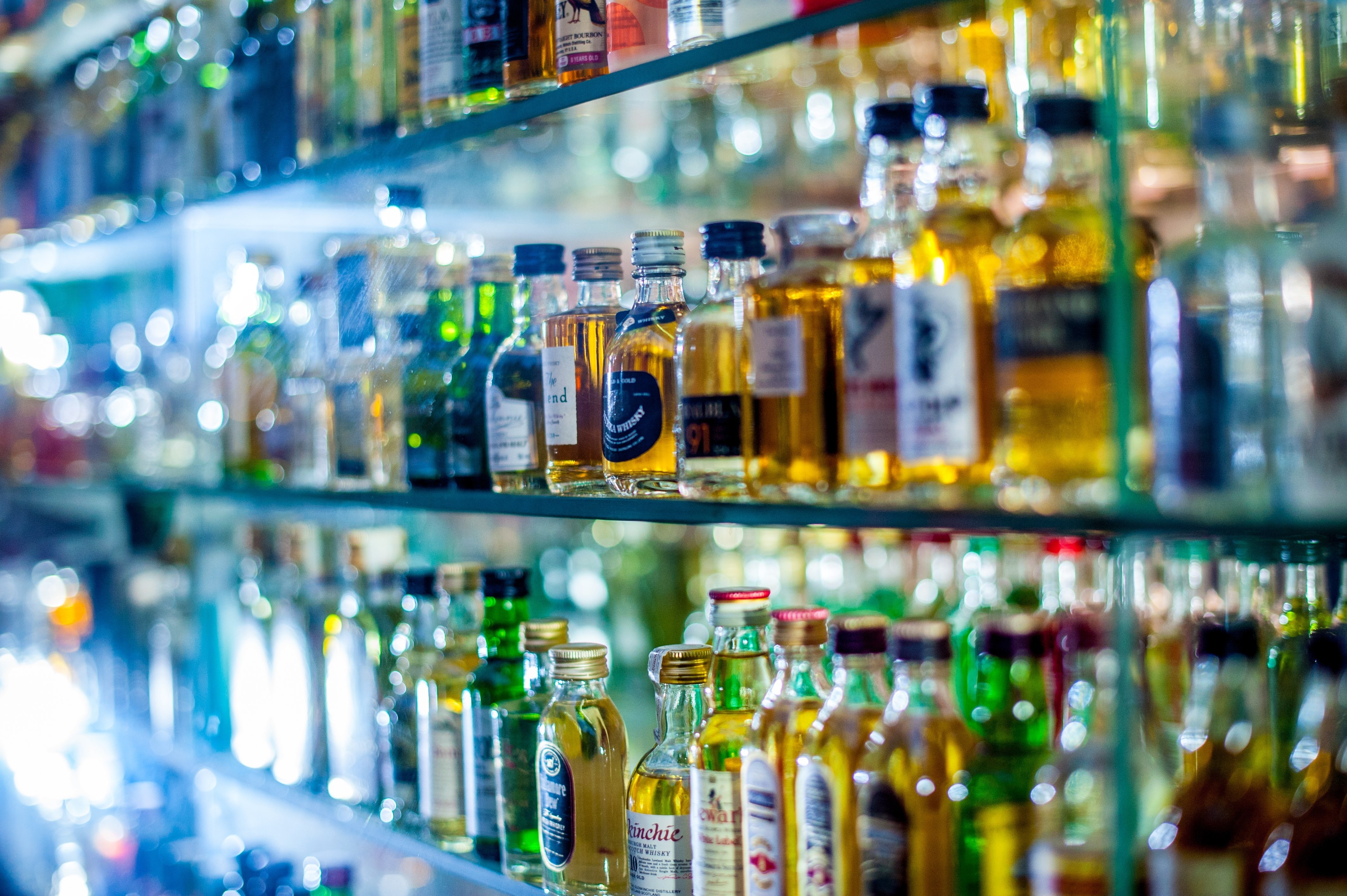 assorted bottles in glass shelves
