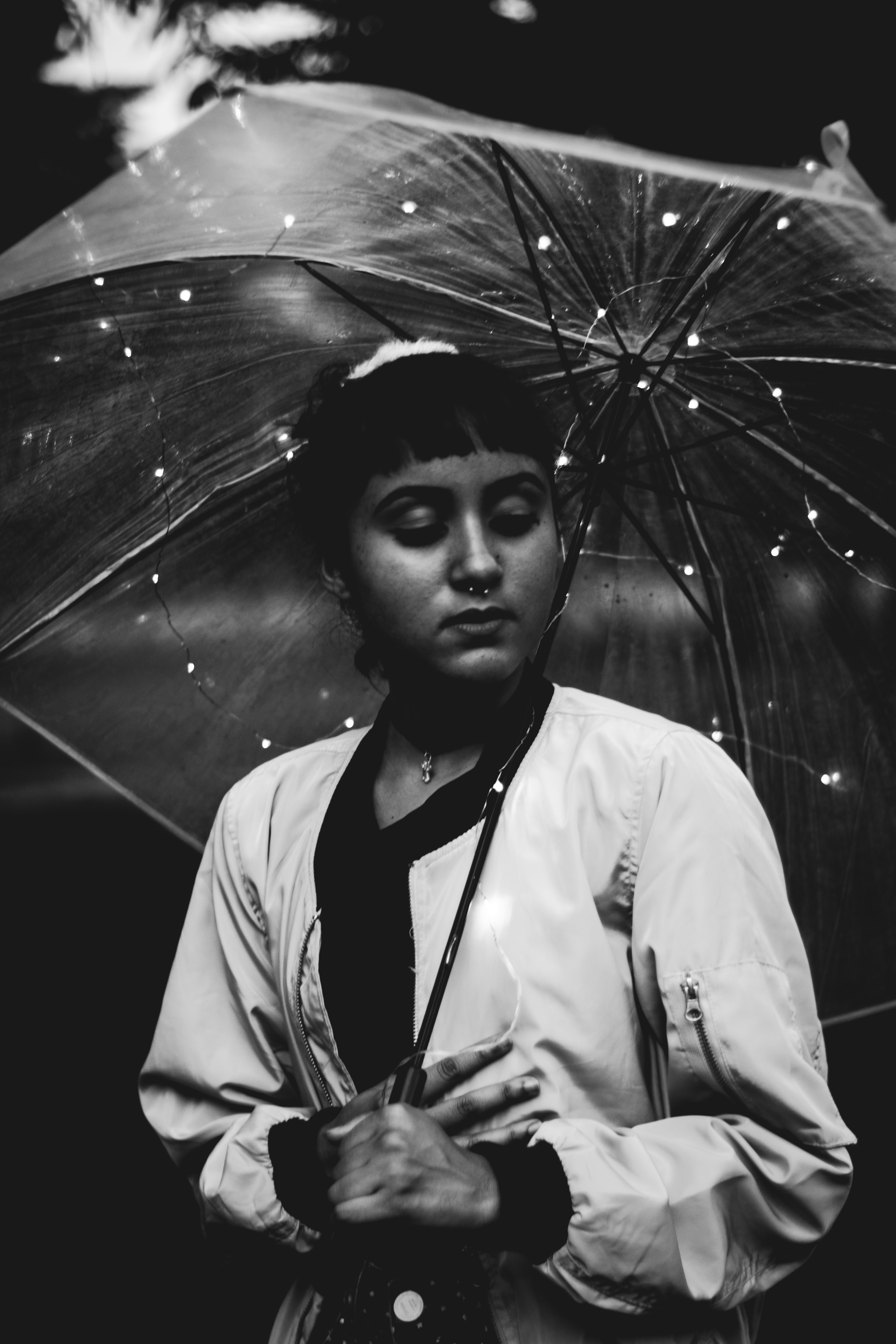 grayscale photograph of a woman under umbrella