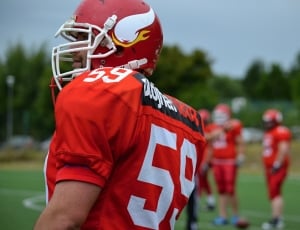 football player in helmet and jersey thumbnail