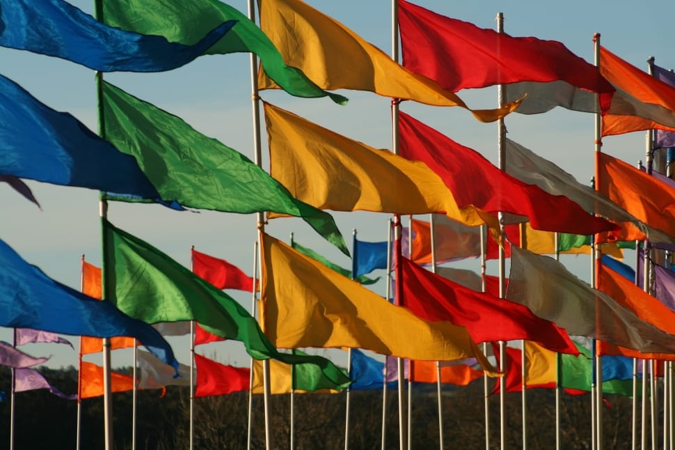 assorted flags under blue skies during daytime preview