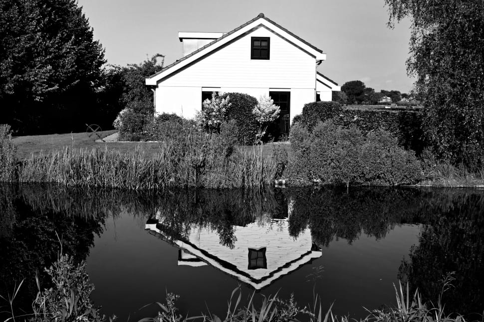 grayscale photography of house near body of wate preview
