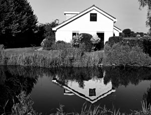 grayscale photography of house near body of wate thumbnail
