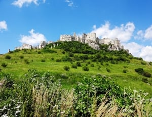 gray stone castle on top of green mountain thumbnail
