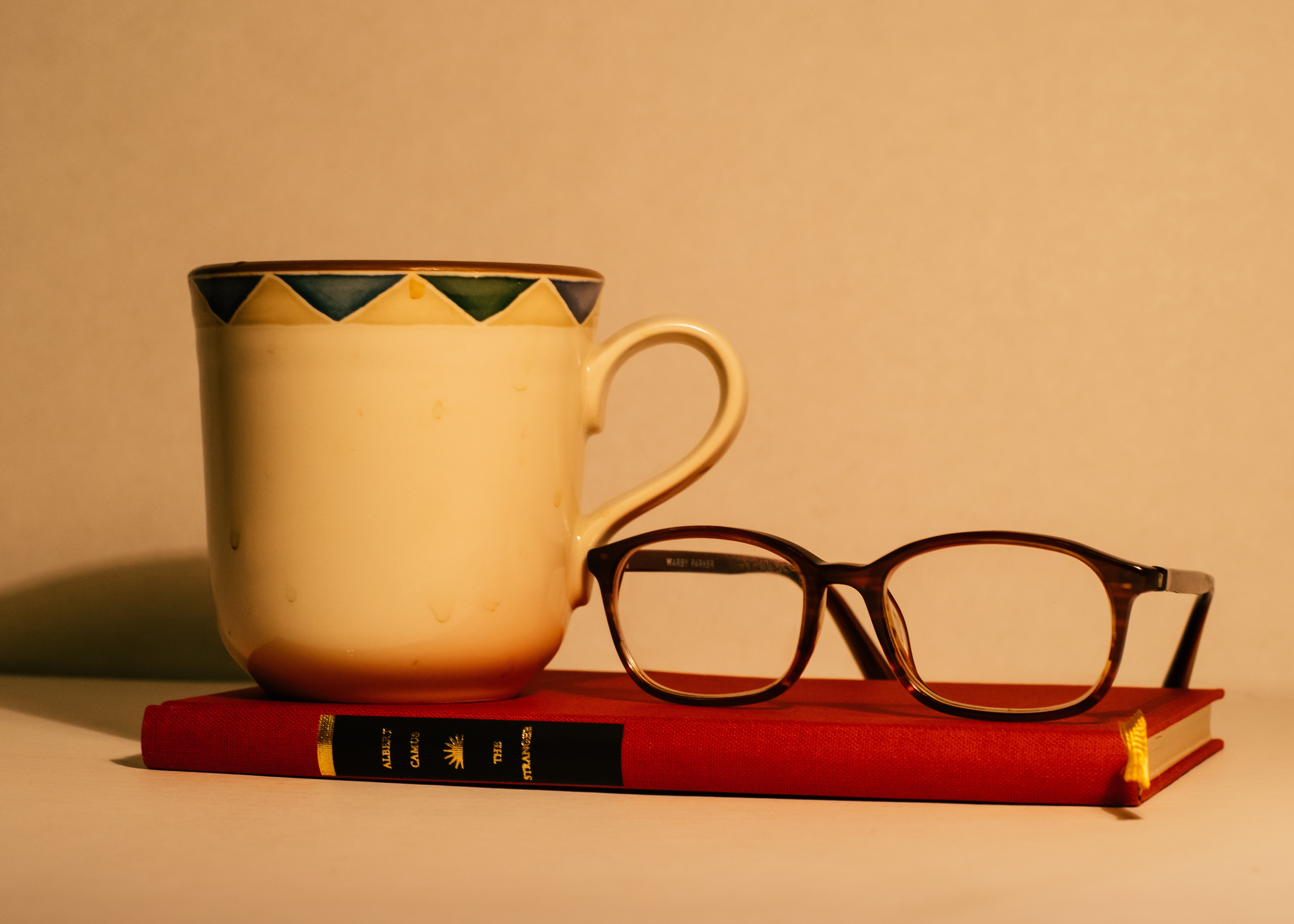 brown frame eyeglasses book and mug