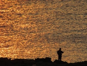 silhouette of man near body of water thumbnail