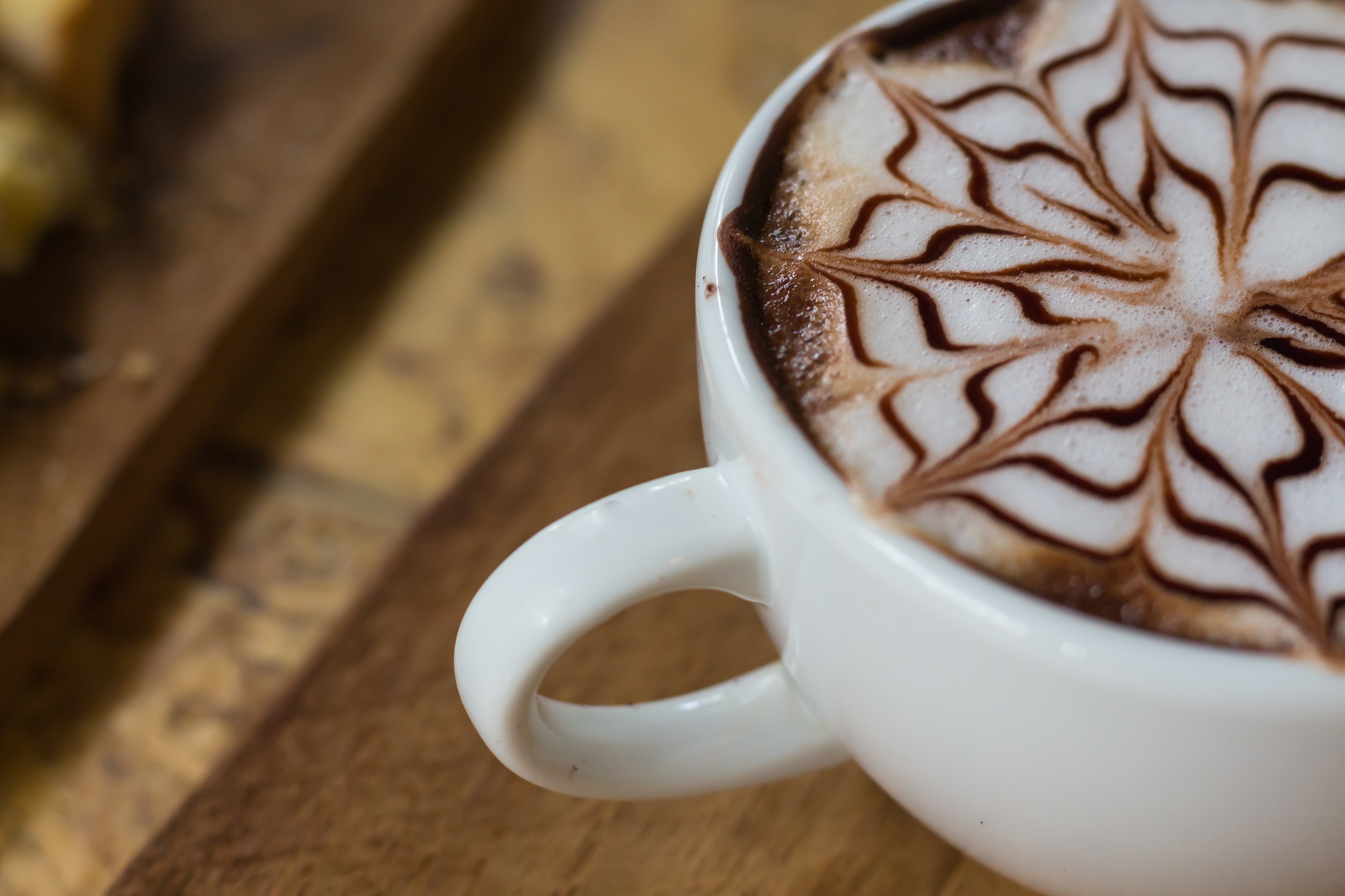 latte art on brown ceramic mug
