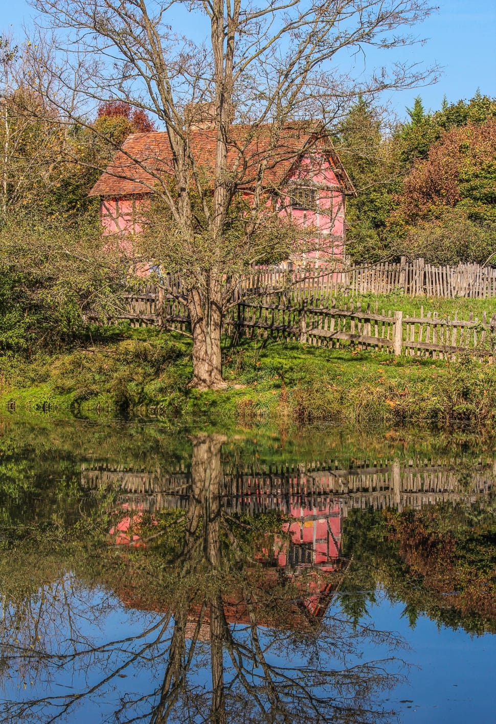pink house near body of water during daytime preview