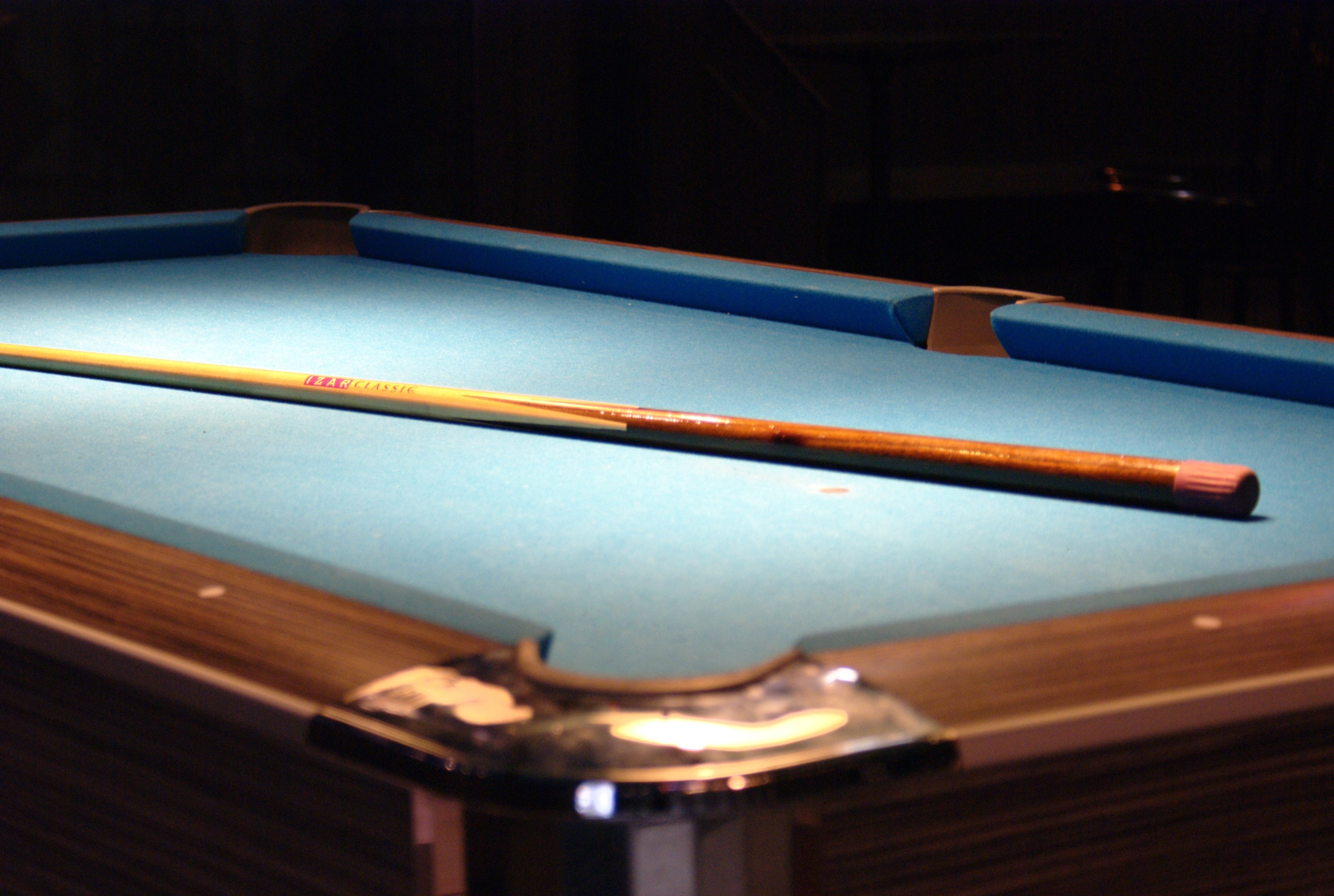 brown and blue billiard table and cue stick