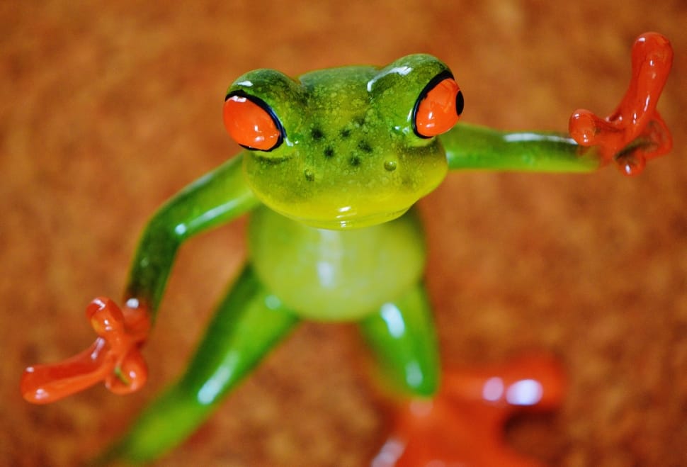 Royalty-Free photo: Green and red ceramic frog figurine on white