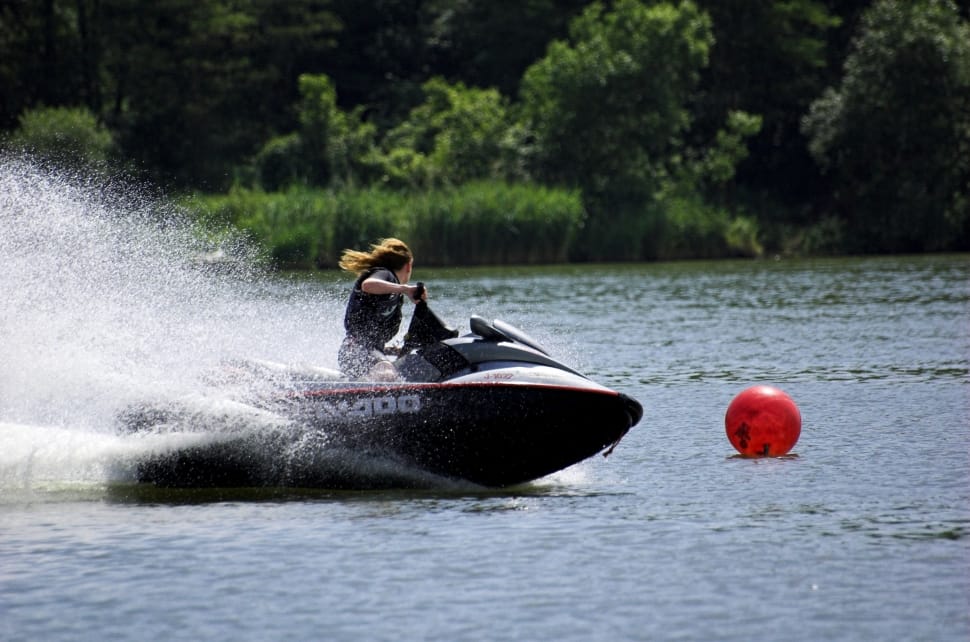 person riding a black personal water craft during day time preview