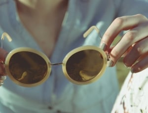 person holding silver framed white sunglasses thumbnail