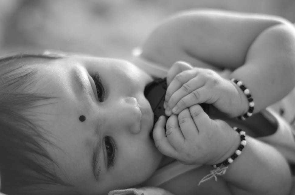 baby with bracelets grayscale photography preview