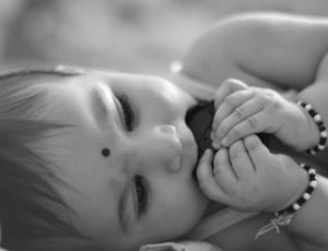 baby with bracelets grayscale photography thumbnail