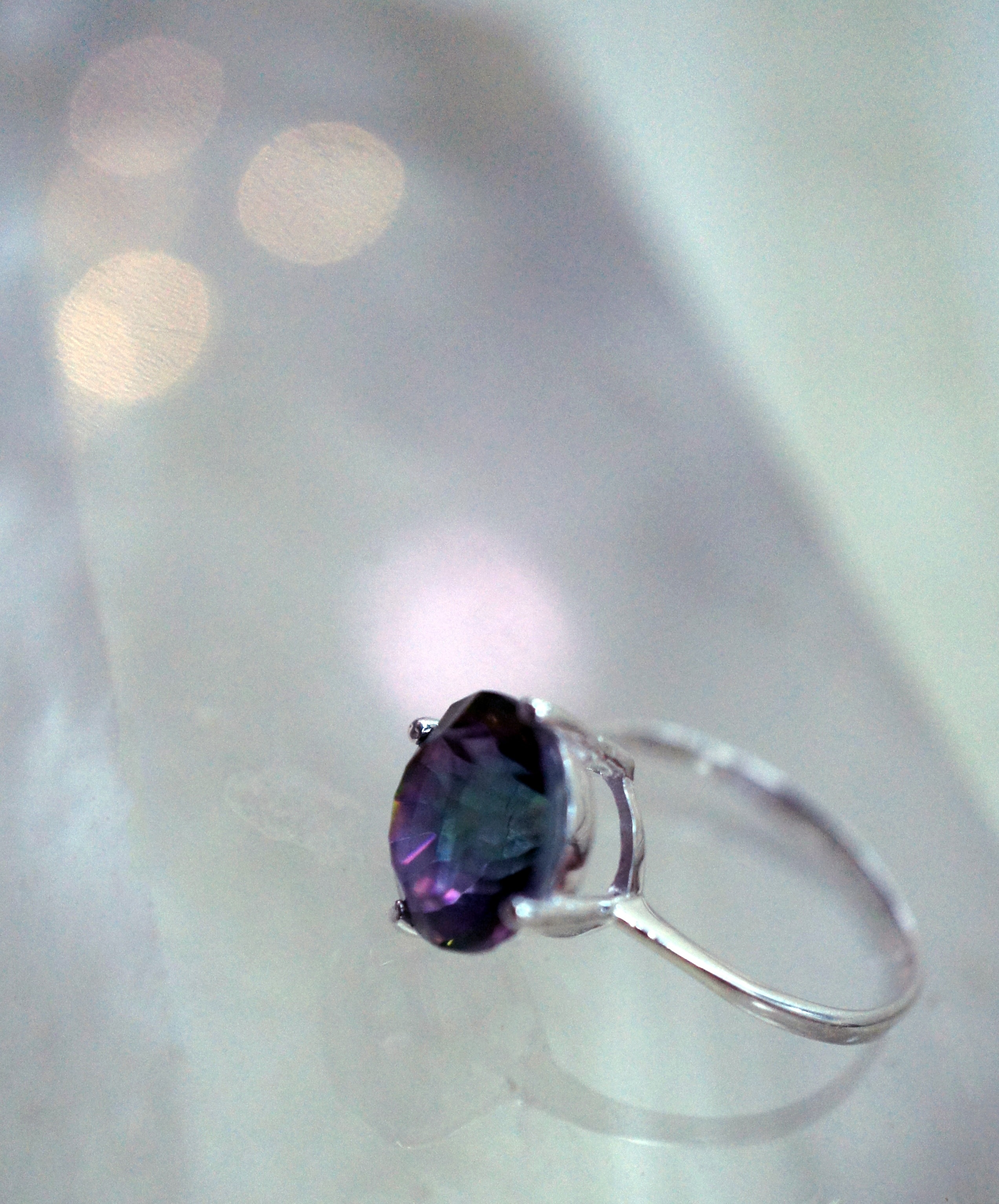 silver and blue gemstone ring on white surface