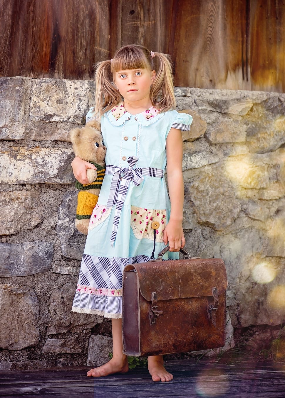 girl's green and blue short sleeve dress and brown leather suitcase preview
