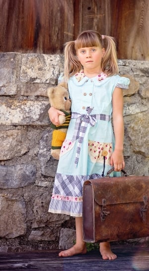 girl's green and blue short sleeve dress and brown leather suitcase thumbnail