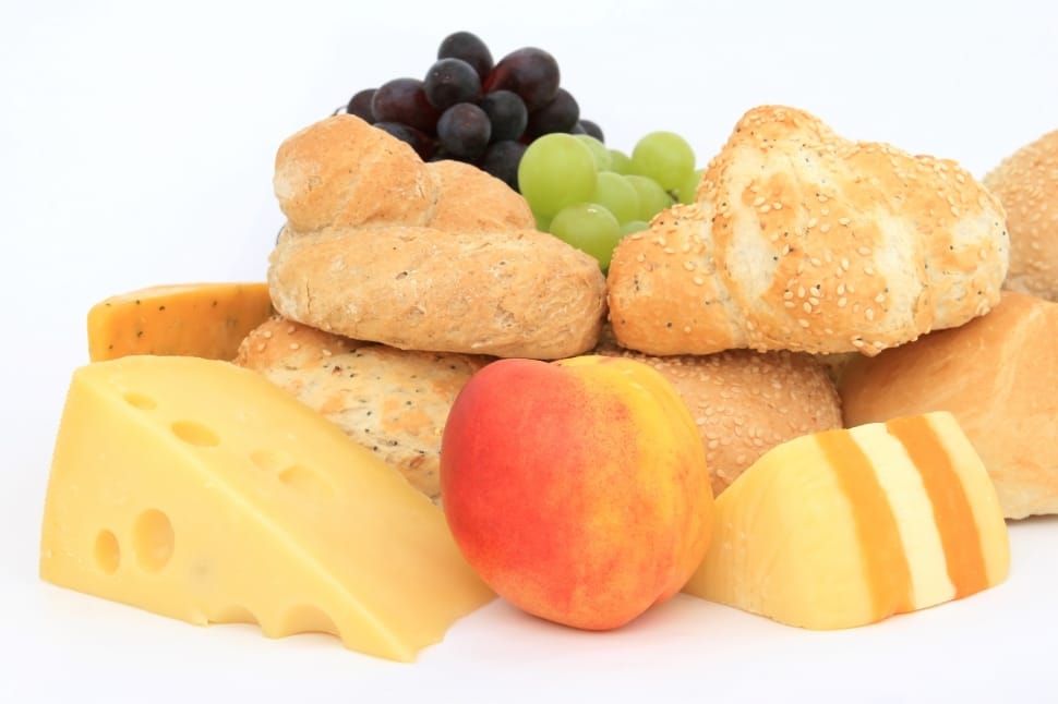 purple and green grapes, bread coated in sesame seeds, apple fruit and sliced cheese preview