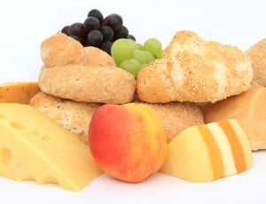 purple and green grapes, bread coated in sesame seeds, apple fruit and sliced cheese thumbnail