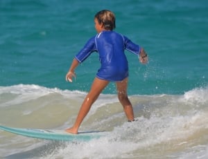 boy in blue surfing on blue sea thumbnail