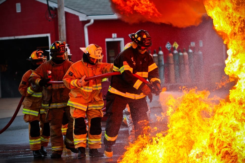 four fireman holding fire-hose near fire preview
