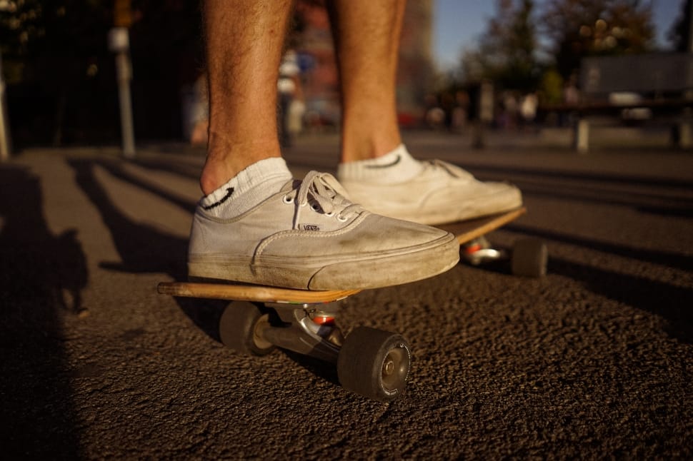 person wearing beige low top sneakers riding black skateboard preview
