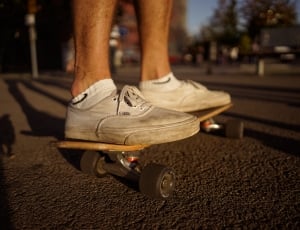 person wearing beige low top sneakers riding black skateboard thumbnail