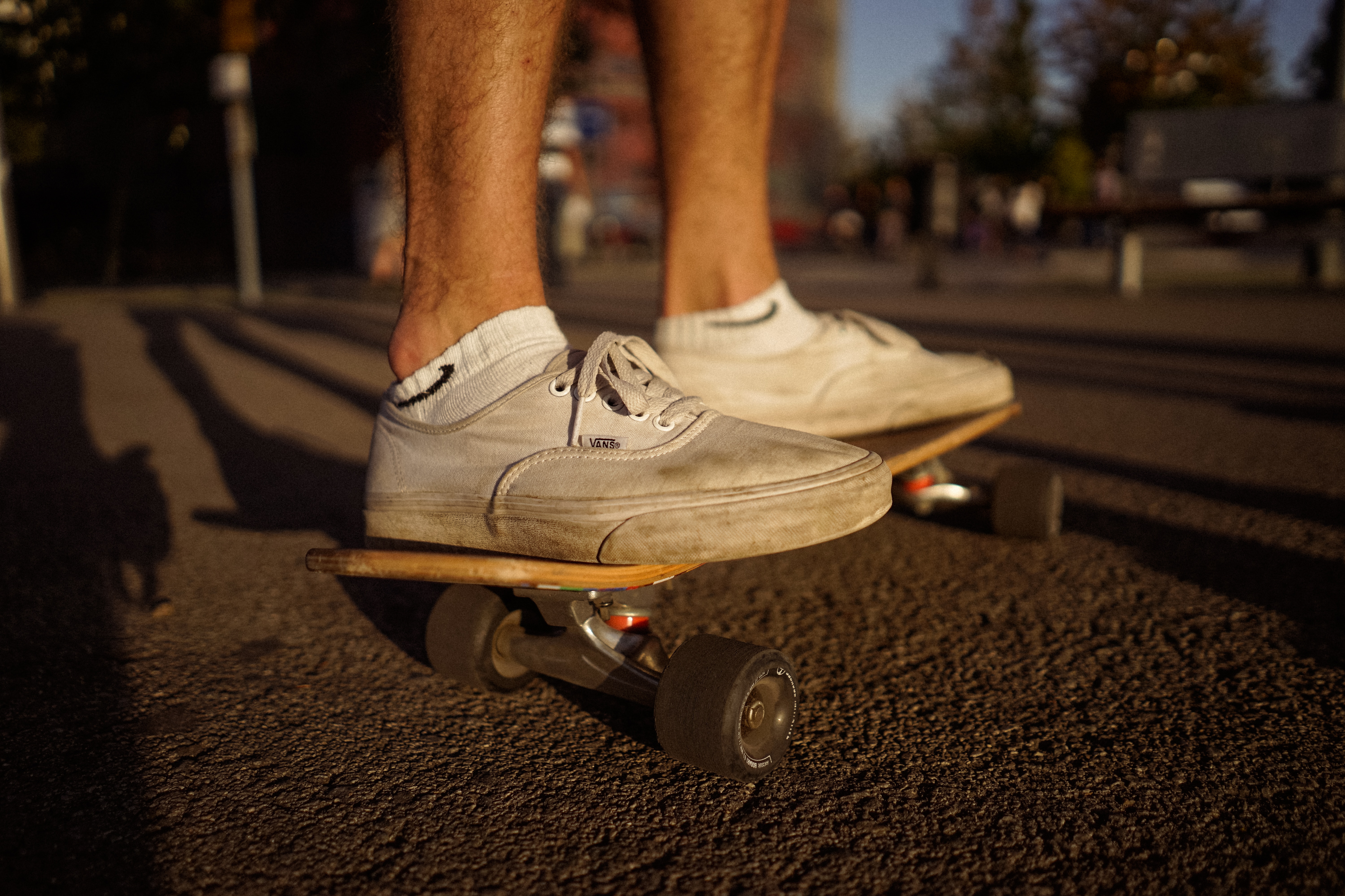 person wearing beige low top sneakers riding black skateboard