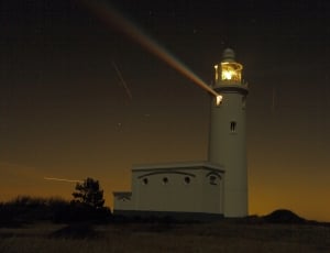 lighted white lighthouse during golden hour thumbnail
