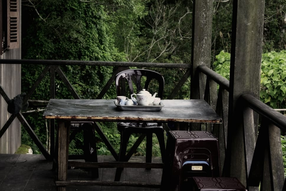 white ceramic teapot and cup set in black wooden patio table near terrace free image - Peakpx