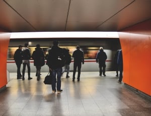 people in jackets standing near train thumbnail