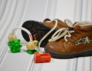 pair of black-and-brown leather boots and plastic toys thumbnail