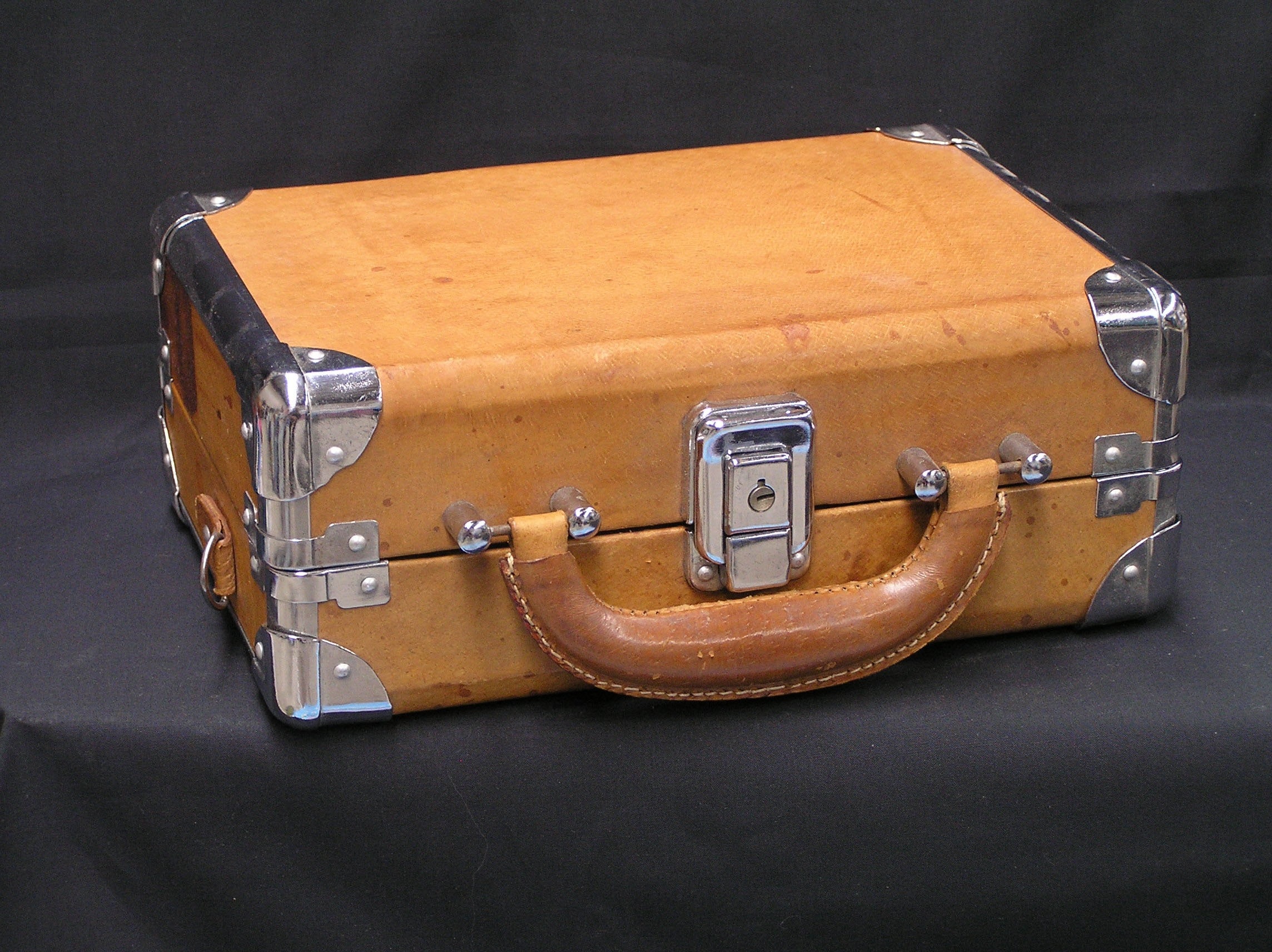 brown leather suitcase on black textile
