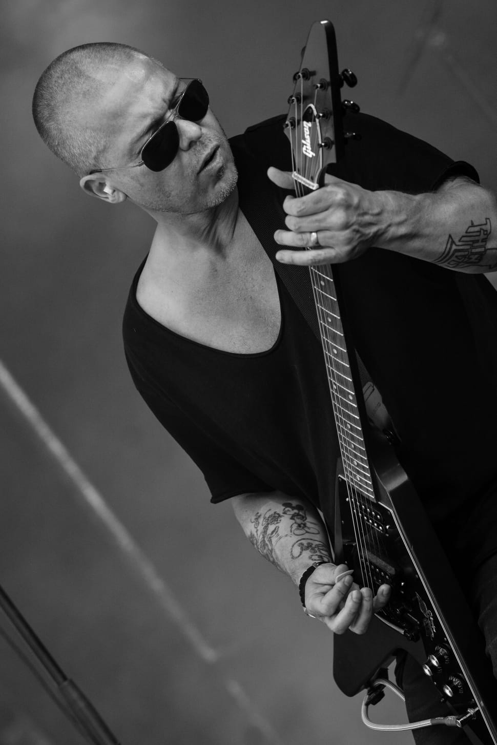 man playing guitar with scoop neck t-shirt in grayscale photo preview