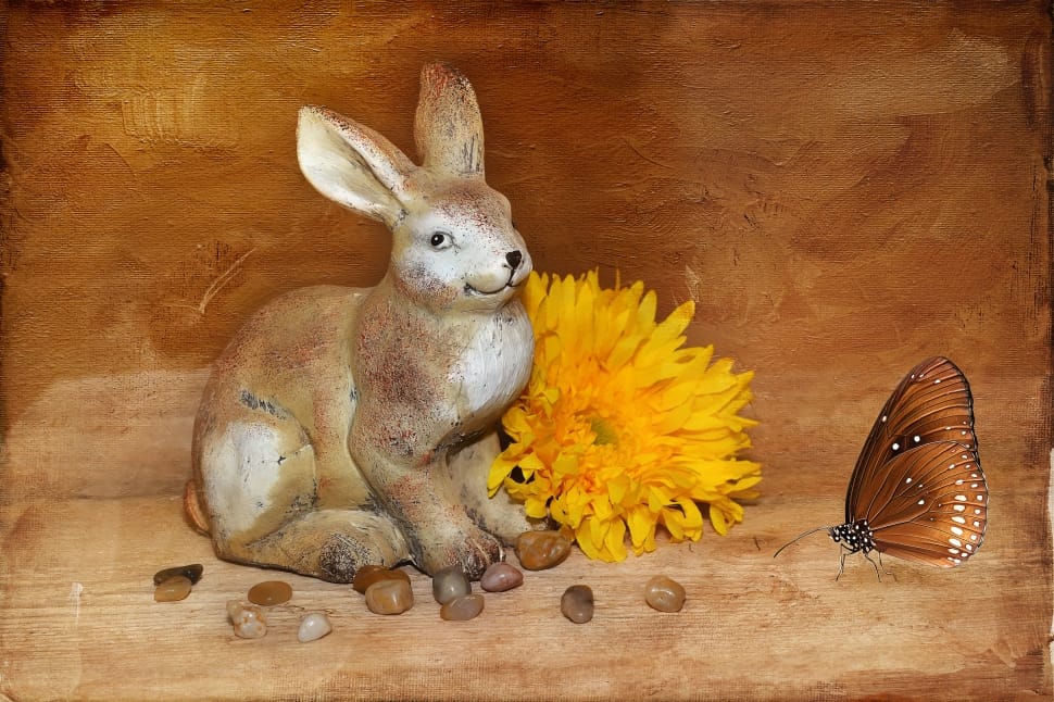 brown ceramic hare figurine beside sunflower and butterfly figurine preview