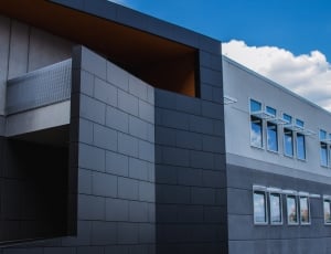 gray and black  concrete building under blue and white cloudy sky thumbnail