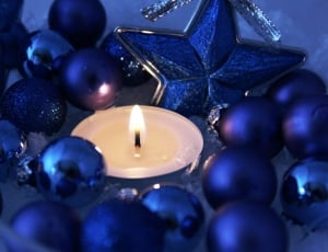 white candle beside blue beads thumbnail