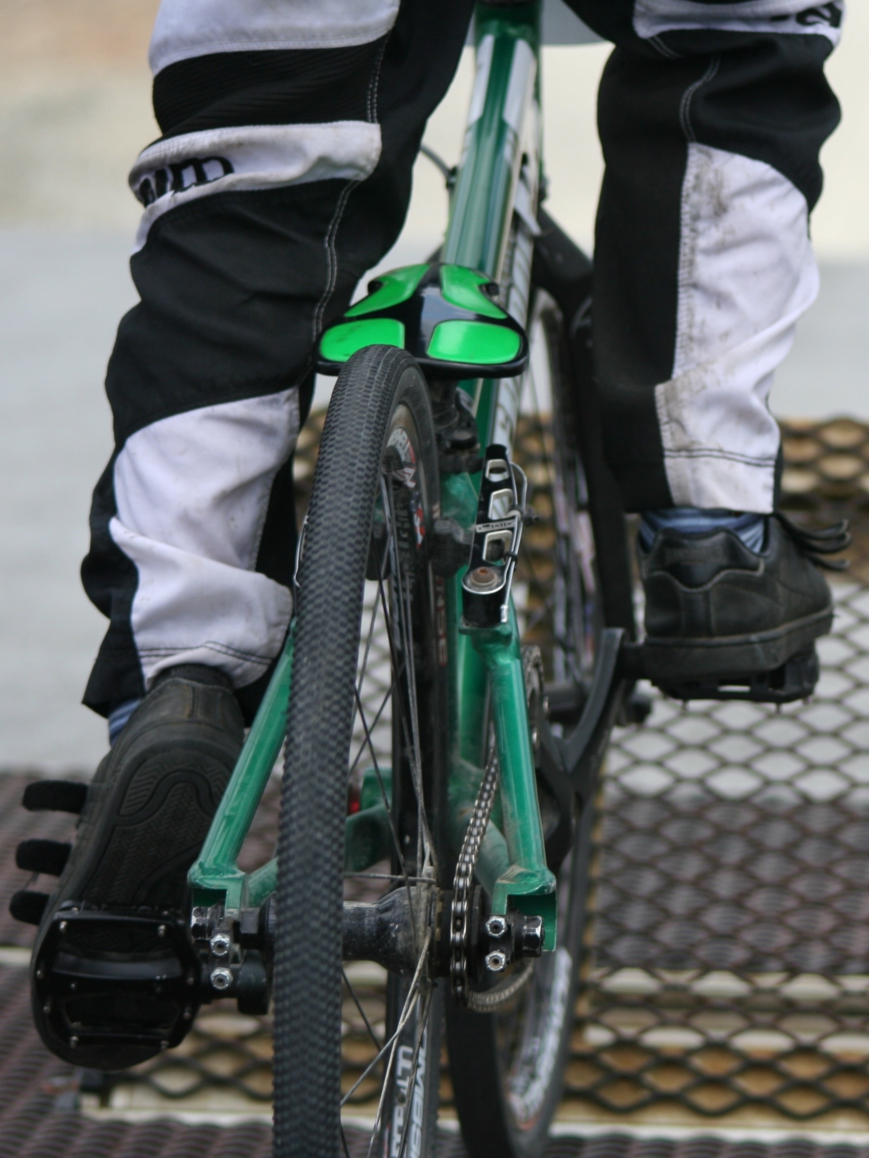person riding green hardtail bike of concrete surface