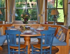 brown wooden table and brown and blue wooden chairs thumbnail