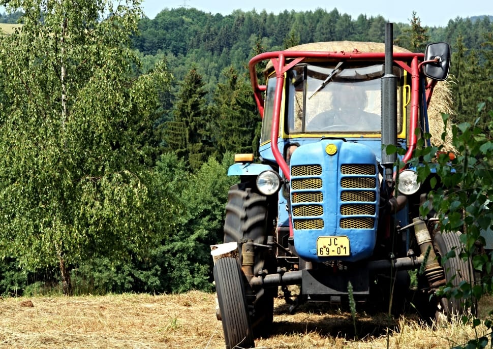 human riding tractor in field preview