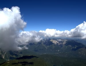 top view of green mountains under white clouds and blue sky during daytime thumbnail